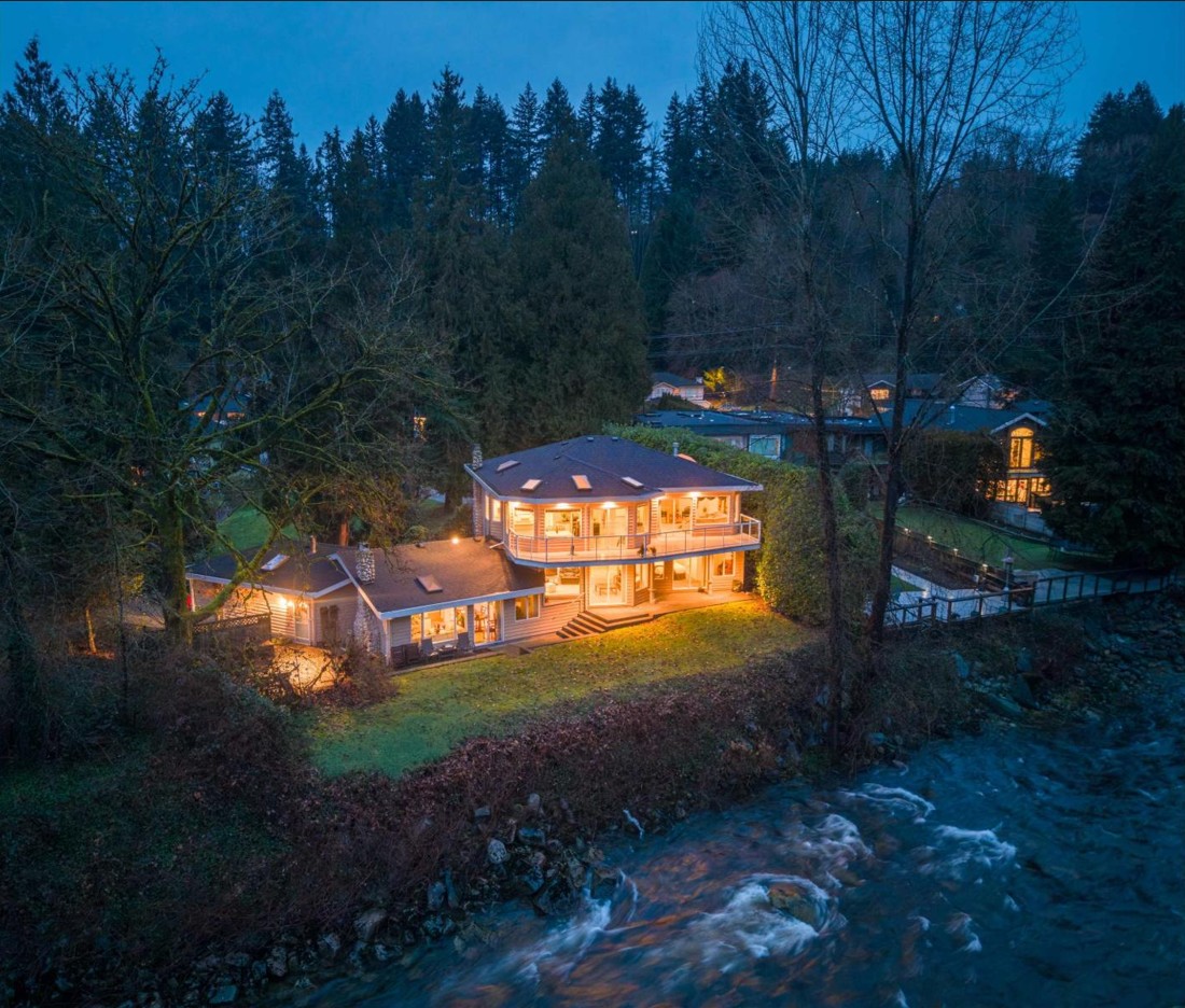 The house lit at dusk above the Seymour River